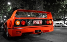 Красный Ferrari F40 на обочине черно-белого города